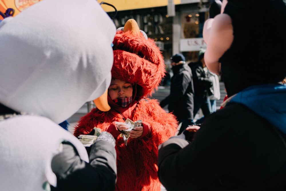 person in elmo costume counting money