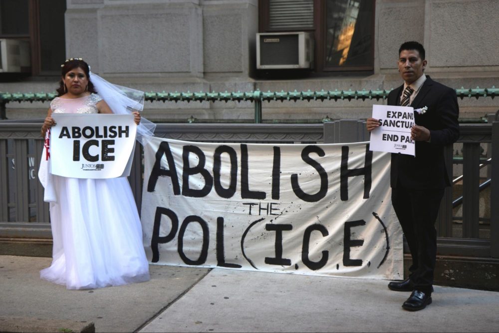 Man and woman holding "abolish ICE" sign
