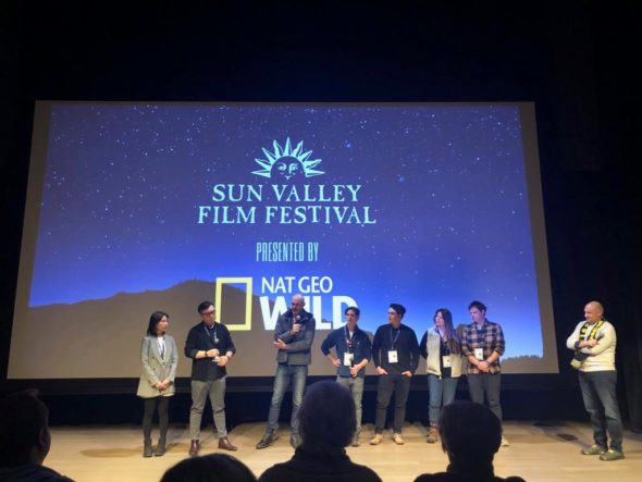 eight people stand on a stage in a movie theater at Sun Valley Film Festival