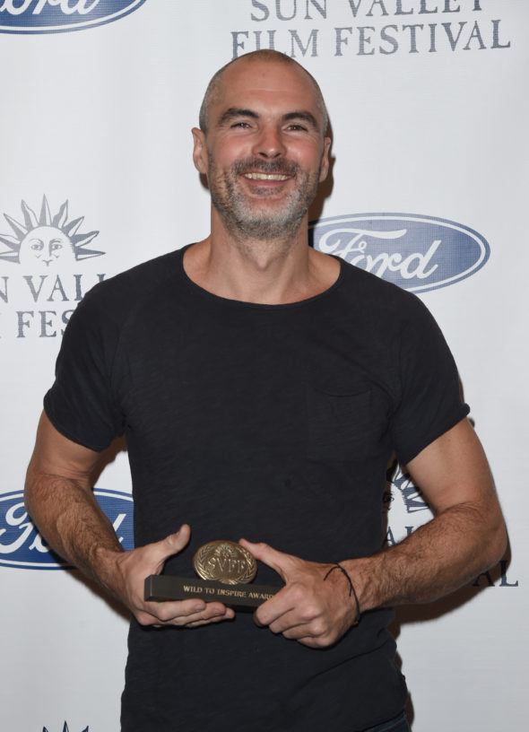 white man in a black shirt holding a Sun Valley Film Festival award